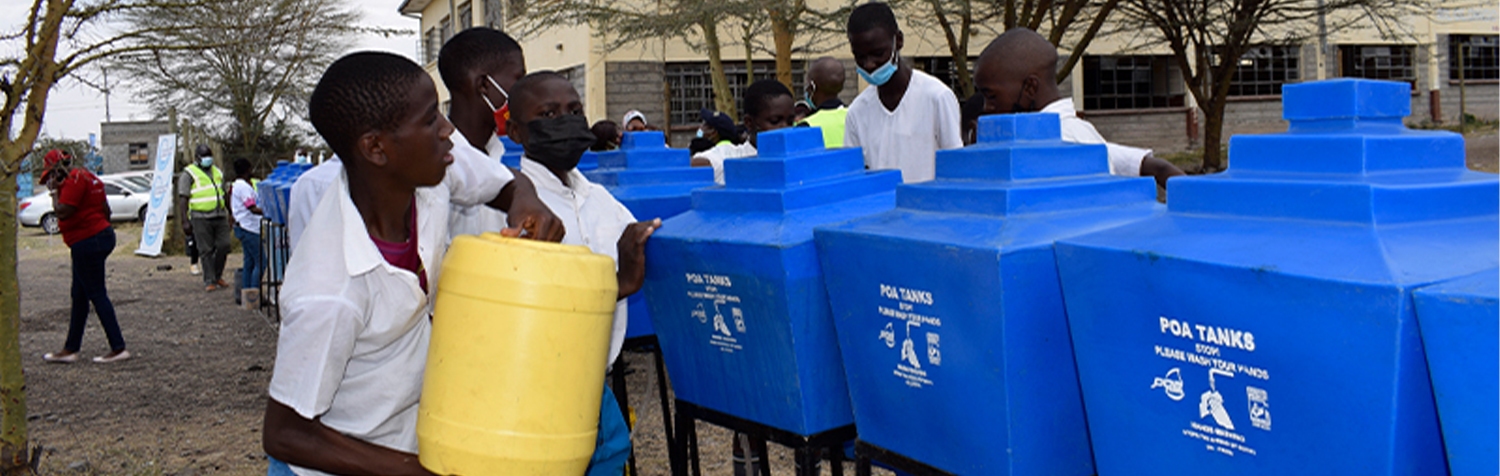 Boy refilling POA handwashing Tank